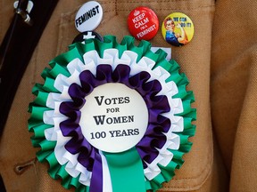 A participant wears a rosette in a march through the streets of London, England, on June 10, 2018, to celebrate 100 years since women were granted the vote.