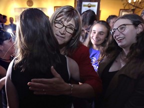 Vermont Democratic gubernatorial candidate Christine Hallquist, center, a transgender woman and former electric company executive, embraces supporters after claiming victory during her election night party in Burlington, Vt., Tuesday, Aug. 14, 2018.