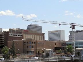 In this photo taken June 4, 2018, a construction crane looms over downtown and the Monroe Street Bridge in Spokane, Wash.  The state's second-largest city is booming these days thanks to a good economy and influx of new residents.