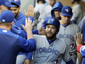 Toronto Blue Jays' Russell Martin, center, is greeted in the dugout after he hit a solo home run against the Seattle Mariners during the fourth inning of a baseball game Friday, Aug. 3, 2018, in Seattle.