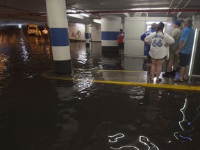 Toronto Blue Jays fans get stuck in the Rogers Centre as the entrance to the parking garage floods with torrential rain, in Toronto on Tuesday, August 7, 2018.