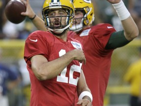 Green Bay Packers quarterback Aaron Rodgers reacts to one of his passes during a quarterbacks drill during the NFL football team's Family Night practice Saturday, Aug. 4, 2018, in Green Bay, Wis.