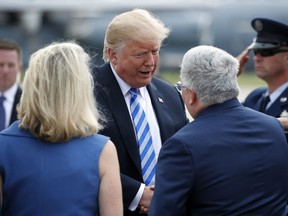 President Donald Trump, center, greets Republican Senate candidate Patrick Morrisey, right, currently West Virginia Attorney General, as he steps off Air Force One, Tuesday, Aug. 21, 2018, in Charleston, W.V.