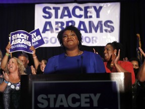 FILE - In this May 22, 2018, file photo, Georgia Democratic gubernatorial candidate Stacey Abrams smiles before speaking to supporters during an election-night watch party in Atlanta. More women than ever before have won their primaries for governor, U.S. Senate and House this year. That's setting a record and paving the way for battles in November that could significantly increase the number of women in elected office.