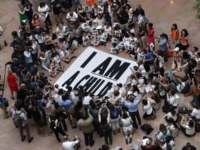 FILE - In this July 26, 2018, file photo, families with young children protest the separation of immigrant families with a sit-in at the Hart Senate Office Building on Capitol Hill in Washington. The government has made only incremental improvements to its troubled efforts to care for thousands of migrant children detained entering the U.S. without their parents, perpetuating a problem the Trump administration has aggravated with its "zero tolerance" immigration crackdown, a bipartisan Senate report said Wednesday, Aug. 15.