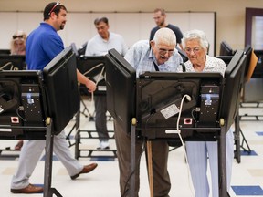 In this Aug. 7, 2018, photo, voters cast their ballots among an array of electronic voting machines in a polling station at the Noor Islamic Cultural Center, Tuesday, Aug. 7, 2018, in Dublin, Ohio. An Associated Press analysis find Democrats with a consistent enthusiasm advantage with nearly a dozen federal special elections now concluded ahead of the November midterms.