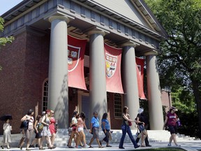 FILE - In this Aug. 30, 2012, file photo, a tour group walks through the campus of Harvard University in Cambridge, Mass. The Justice Department has sided with Asian-American students suing Harvard University over the Ivy League school's consideration of race in its admissions policy.