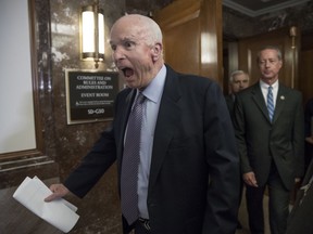 FILE - In this Oct. 25, 2017, file photo Senate Armed Services Chairman John McCain, R-Ariz., followed at right by House Armed Services Chairman Mac Thornberry, R-Texas, makes a humorous face to reporters on Capitol Hill in Washington. McCain died on Aug. 25, 2018, after battling brain cancer. McCain's "wicked" wit was often aimed at himself over long Washington career.