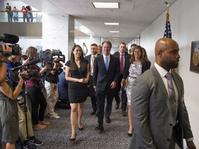 In this Aug. 15, 2018, photo, Supreme Court nominee Brett Kavanaugh, center, walks to the office of Sen. Heidi Heitkamp, D-N.D., for a meeting with her on Capitol Hill in Washington. Kavanaugh is set to meet with Republican Sen. Susan Collins of Maine, a centrist who's seen as a potential swing vote on his confirmation. Collins supports abortion rights, but has spoken highly of President Donald Trump's nominee. Kavanaugh is also meeting separately with Democratic leader Chuck Schumer of New York.