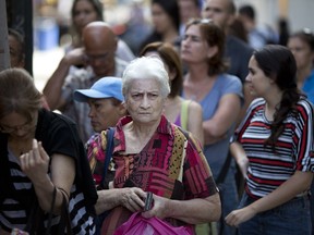 People line up to buy cheese at a market in Caracas, Venezuela, Saturday, Aug. 18, 2018. Venezuelan President Nicolas Maduro raised wages for the fifth time this year while saying he's looking to establish a single exchange rate tied to the nation's fledgling cryptocurrency.