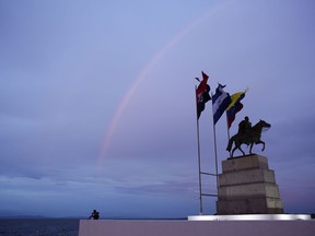 A rainbow crosses the sky over a statue of Simon Bolivar on the shore of Managua Lake at sunset in Managua, Nicaragua, Wednesday, Aug. 1, 2018.