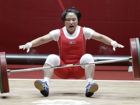 North Korean Ri Song Gum falls during her attempt at the women's 48kg weightlifting games at the 18th Asian Games in Jakarta, Indonesia on Monday, Aug. 20, 2018. Ri won gold.