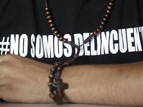 In this Saturday, July 28, 2018 photo, Jairo Bonilla, leader of the April 19 student movement, wears a T-shirt with text that reads in Spanish "We are not criminals," during an interview with the Associated Press in Managua, Nicaragua. The Inter-American Commission on Human Rights has said its monitoring team in Nicaragua found that "Nicaraguan authorities made numerous arbitrary detentions involving the use of force."