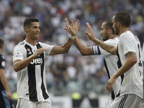 Juventus' Cristiano Ronaldo, left, celebrates with Juventus' Giorgio Chiellini, second right after their teammate Juventus' Miralem Pjanic scored the opening goal of the game during the Serie A soccer match between Juventus and Lazio at the Allianz Stadium in Turin, Italy, Saturday, Aug. 25, 2018.