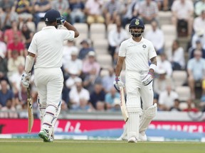 India's Cheteshwar Pujara, left goes to congratulate India's Virat Kohli who passes 6000 test match runs scored during play on the second day of the 4th cricket test match between England and India at the Ageas Bowl in Southampton, England, Friday, Aug. 31, 2018. England and India are playing a 5 test series.