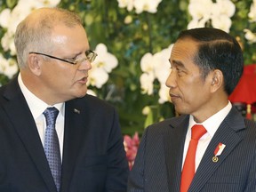 Australian Prime Minister Scott Morrison, left, talks to Indonesian President Joko Widodo, right, during a signing ceremony at the presidential palace in Bogor, West Java, Indonesia, Friday, Aug. 31, 2018.