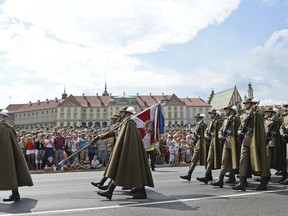 Polish Army soldiers march on one of the city's main streets during a yearly military parade celebrating the Polish Army Day in Warsaw, Poland, Wednesday, Aug. 15, 2018, with the Royal Castle in the background.