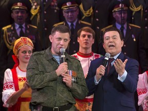 FILE In this file photo taken on Monday, Oct. 27, 2014, Russian singer Iosif Kobzon, right, and Pro-Russian rebel leader Alexander Zakharchenko sing together during Iosif Kobzon's concert in the town of Donetsk, eastern Ukraine. Kobzon, an iconic Russian crooner and lawmaker dubbed "the Soviet Sinatra" for his decades-long career, has died. He was 80. The Russian State Duma said in a statement that Kobzon died earlier on Thursday, Aug. 30, 2018.