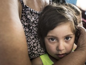 In this photo taken on Monday, June 4, 2018 and provided by OSCE Project Co-ordinator in Ukraine Press Service, a mother embraces her daughter as other Roma gather to attend a religion service in a church inside a Roma encampment on the outskirts of Uzhgorod, western Ukraine. After attackers charged into a Roma encampment on the outskirts of Kiev, a leader of an ultranationalist group posted photos of his colleagues clearing the site and burning tents left behind. The April attack was the first of 11 forced removals that civilians in Ukraine carried out at Roma settlements an ethnic group, also known as Gypsies, that faces discrimination and disdain in much of Europe.