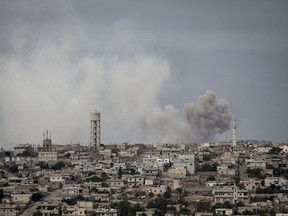 FILE - In this Sept. 19, 2013, file photo, smoke rises after a TNT bomb was thrown from a helicopter, hitting a rebel position during heavy fighting between troops loyal to president Bashar Assad and opposition fighters, in a neighbouring village to Kafr Nabuda, in the Idlib province countryside, Syria. The campaign for Idlib, the opposition's only remaining stronghold in the country and now a refuge for over one million displaced Syrians, is likely to be the last major theater of battle after seven years of brutal civil war. (AP Photo/File)