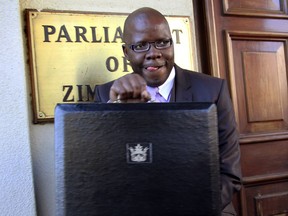 FILE - In this July, 18, 2012 file photo Tendai Biti, stands outside the Parliament Building in Harare, Zimbabwe. A Zimbabwean lawyer says that senior opposition official Tendai Biti has been arrested. Nqobizitha Mlilo, the lawyer, said Biti was arrested Wednesday, Aug. 8, 2018 while trying to cross into Zambia.