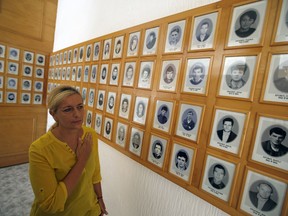 A Bosnian Serb woman Radojka Filipovic walks through the memorial room for Bosnian Serb victims killed by Bosnian Muslim soldiers in Bratunac, Bosnia, Tuesday, Aug. 14, 2018. President of Bosnian Serbs Milorad Dodik has downplayed the massacre of some 8,000 Bosnian Muslims in Srebrenica during the war in 1995 and called for the reopening of an investigation into the worst carnage in Europe since World War II.