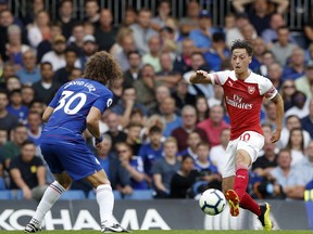 Arsenal's Mesut Ozil, right, duels for the ball with Chelsea's David Luiz during the English Premier League soccer match between Chelsea and Arsenal at Stamford bridge stadium in London, Saturday, Aug. 18, 2018.