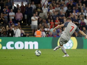 Liverpool's James Milner scores his side's opening goal from penalty during the English Premier League soccer match between Crystal Palace and Liverpool at Selhurst Park stadium in London, Monday, Aug. 20, 2018.