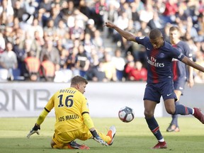 Angers goalkeeper Ludovic Butelle, left, makes a save in front of PSG's Kylian Mbappe during the French League One soccer match between Paris Saint Germain and Angers at the Parc des Princes stadium in Paris, Saturday, Aug. 25, 2018.
