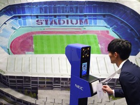 A staff demonstrates a new face recognition system used for the Tokyo 2020 Olympic and Paralympic Games during a press conference in Tokyo Tuesday, Aug. 7, 2018. The NeoFace technology developed by NEC Corp. will be used across the Olympics for the first time as Tokyo organizers work to keep security tight and efficient at dozens of venues during the 2020 Games.