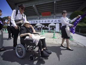 102-year-old Harumi Serigano who lost her husband during the WWII in Okinawa with other bereaved family members arrive for a national memorial ceremony for the war dead at Nippon Budokan martial arts hall Wednesday, Aug. 15, 2018, in Tokyo. Japan marked Wednesday the 73rd anniversary of the end of World War II.
