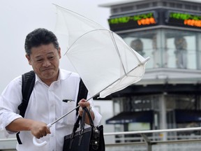 A man walks in wind and rain as Typhoon Shanshan approaches in Iwaki, Fukushima Prefecture, northern Japan Thursday, Aug. 9, 2018. (Kyodo News via AP)