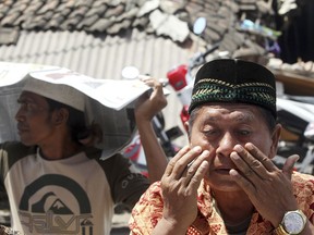 A man weeps as he prays during Muslim Friday prayers in North Lombok, Indonesia, Friday, Aug. 10, 2018. The north of Lombok was devastated by a powerful earthquake that struck Sunday night, damaging thousands of buildings and killing a large number of people.