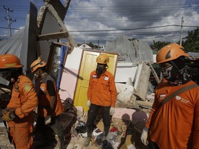 Emergency teams continue to search for victims in an earthquake-damaged house in Tanjung, Lombok, Indonesia, Tuesday, Aug. 7, 2018. Thousand left homeless by a powerful quake that ruptured roads and flattened buildings on the Indonesia tourist island Lombok as authorities said rescuers hadn't yet reached all devastated areas and expect the death toll to climb.