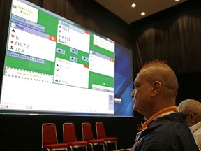 In this Aug. 21, 2018, photo, India's bridge player Finton Lewis watches a bridge match competition on a screen at the 18th Asian Games in Jakarta, Indonesia. The card game of bridge is being included for the first time in the Asian Games. At least two players are over 80. The main promoter of the sport at the games is 78-year-old Indonesian billionaire Michael Bambang Hartono. He is also playing. One player likened bridge to being the "athletics of the mind."