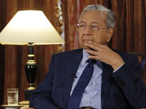 Malaysia's Prime Minister Mahathir Mohamad listens during an interview with The Associated Press in Putrajaya, Malaysia, Monday, Aug. 13, 2018. Mahathir said he will seek to cancel multibillion-dollar Chinese-backed infrastructure projects that were signed by his predecessor as his government works to dig itself out of debt, and he blasted Myanmar's treatment of its Rohingya minority as "grossly unjust."