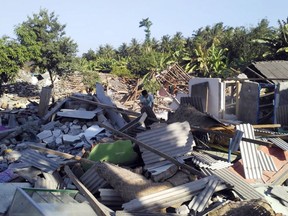 A man inspects destroyed homes following an earthquake on Lombok island, Indonesia, Monday, Aug. 20, 2018. Multiple strong earthquakes killed a number of people on the Indonesian islands of Lombok and Sumbawa as the region was trying to recover from a temblor earlier this month that killed hundreds of people.