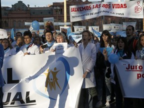 In this July 15, 2018 photo, medical doctors protest against efforts to legalize abortion, in front of Government House in Buenos Aires, Argentina. Hundreds of physicians have staged anti-abortion protests as an abortion rights bill moves toward a vote in the Senate.