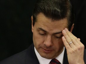 FILE - In this March 7, 2018 file photo, Mexican President Enrique Pena Nieto touches his head during an event focusing on women in honor of the upcoming Women's Day, at Los Pinos presidential residence in Mexico City. Pena Nieto has again defended on Wednesday, Aug. 29, the widely criticized original investigation of the 2014 disappearance of 43 students, but concedes that his administration has failed to bring the country peace.
