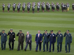 In this Aug. 14, 2018 photo, Colombia's President Ivan Duque, fifth from left, walks with his new Defense Minister Guillermo Botero, fourth from left, as they review troops with military officials during a ceremony in Bogota, Colombia. At the ceremony, Botero formally took command of the armed forces.