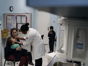 A health worker gives a toddler a dose of the oral polio vaccine, in Rio de Janeiro, Brazil, Monday, Aug. 6, 2018. Brazilian health authorities launched a nationwide vaccination campaign Monday against measles and polio, two diseases that are showing up in larger numbers in Latin America's largest nation after being all but eradicated.