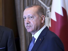 Turkey's President Recep Tayyip Erdogan, as he shakes hands with Qatar's Emir Sheikh Tamim bin Hamad Al Thani prior to their talks at the Presidential Palace in Ankara, Turkey, Wednesday, Aug. 15, 2018. Turkey said Wednesday it is increasing tariffs on some U.S. products like cars, alcohol, and coal _ a move that is unlikely to have much economic impact but highlights the deteriorating relations with the U.S. in a feud that has already helped trigger a currency crisis. (Presidential Press Service via AP, Pool)