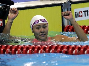 China's Liu Xiang celebrates after winning the women's 50m backstroke final during the swimming competition at the 18th Asian Games in Jakarta, Indonesia, Tuesday, Aug. 21, 2018.