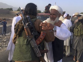 In this June 16, 2018 file photo, Taliban fighters gather with residents to celebrate a three-day cease fire marking the Islamic holiday of Eid al-Fitr, in Nangarhar province, east of Kabul, Afghanistan.