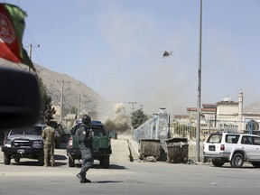 An MD 530F military helicopter targets a house where attackers are hiding in Kabul, Afghanistan, Tuesday, Aug. 21, 2018. The Taliban fired rockets toward the presidential palace in Kabul Tuesday as President Ashraf Ghani was giving his holiday message for the Muslim celebrations of Eid al-Adha, said police official Jan Agha.