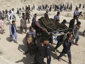 Men carry the coffin of a relative who died in Wednesday's deadly suicide bombing that targeted a training class in a private building in the Shiite neighborhood of Dasht-i Barcha, in western Kabul, Afghanistan, Thursday, Aug. 16, 2018. The Afghan authorities have revised the death toll from the previous day's horrific suicide bombing in a Shiite area of Kabul to 34 killed.