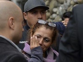 A woman cries as she arrives to find out news of soccer fans killed in a bus crash outside the morgue in Cuenca, Ecuador, Monday, Aug. 13, 2018. At least 12 fans of Ecuadorean football team Barcelona were killed and 30 injured when the bus they were traveling in after a match against Deportivo Cuenca overturned on Sunday.