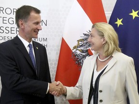 Austrian Foreign Minister Karin Kneissl, right, welcomes Britain's Foreign Secretary Jeremy Hunt, left, for talks at the foreign ministry in Vienna, Austria, Wednesday, Aug. 1, 2018.