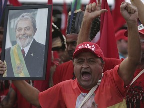 Supporter holds a photo of Brazil's jailed former president Luiz Inacio Lula da Silva, as he takes part in the Free Lula March, in Brasilia, Brazil, Wednesday, Aug.15 2018. Thousands of supporters of the jailed leader and a current presidential candidate, are in Brasilia to monitor the registration of Lula's presidential candidacy, which will be held today by the Workers' Party in the Superior Electoral Court.