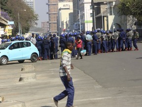 Armed Riot police patrol on a street, in Harare, Friday, Aug. 24, 2018.  Zimbabwe's constitutional court was set to rule Friday afternoon on the main opposition's challenge to the results of last month's historic presidential election. Security was tight in the capital, Harare, as the court will determine whether President Emmerson Mnangagwa's narrow victory is valid. The opposition claims vote-rigging and seeks either a fresh election or a declaration that its candidate, 40-year-old Nelson Chamisa, won.